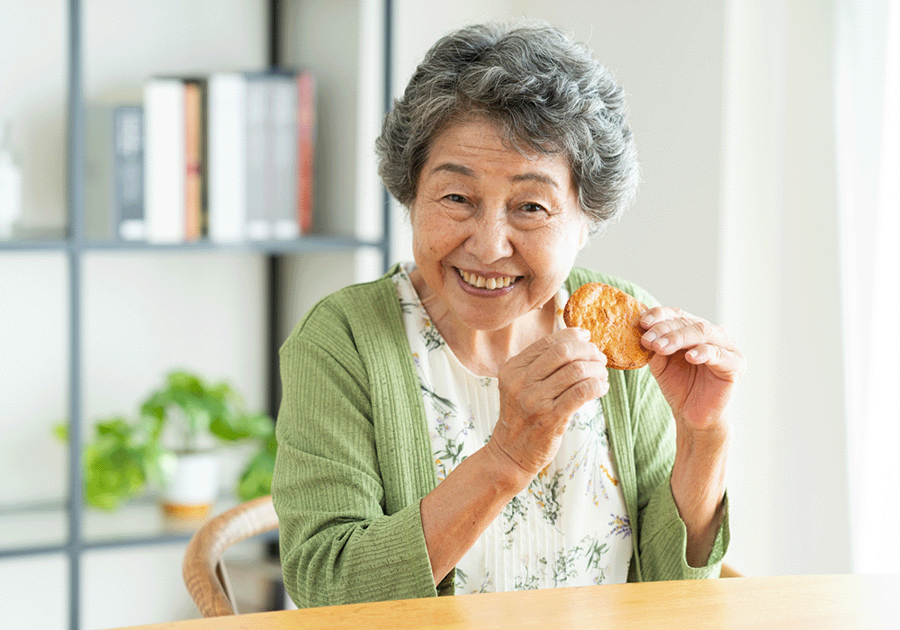 せんべいを持つ高齢女性