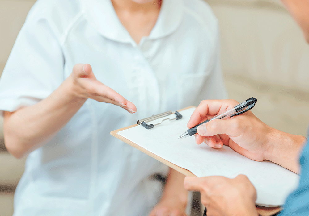 問診表記入を促す歯科衛生士