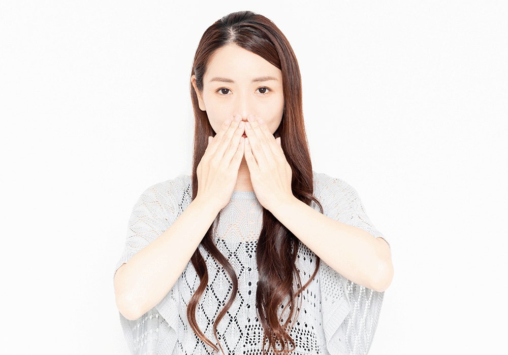 口元に手を当てる女性